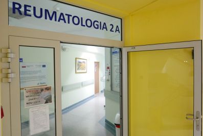 Zdjęcie przedstawia otwarte drzwi wejściowe wiodące do jednego ze szpitalnych oddziałów - oddziału reumatologicznego. 